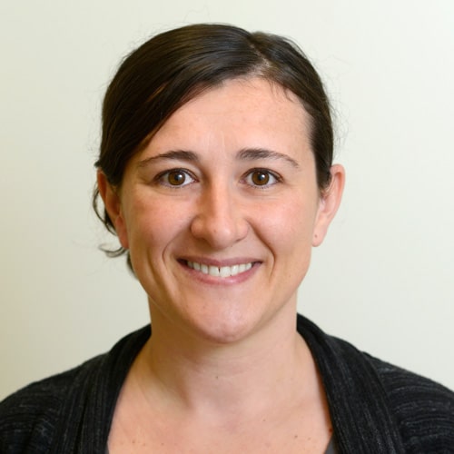 Headshot of a smiling woman with dark brown hair